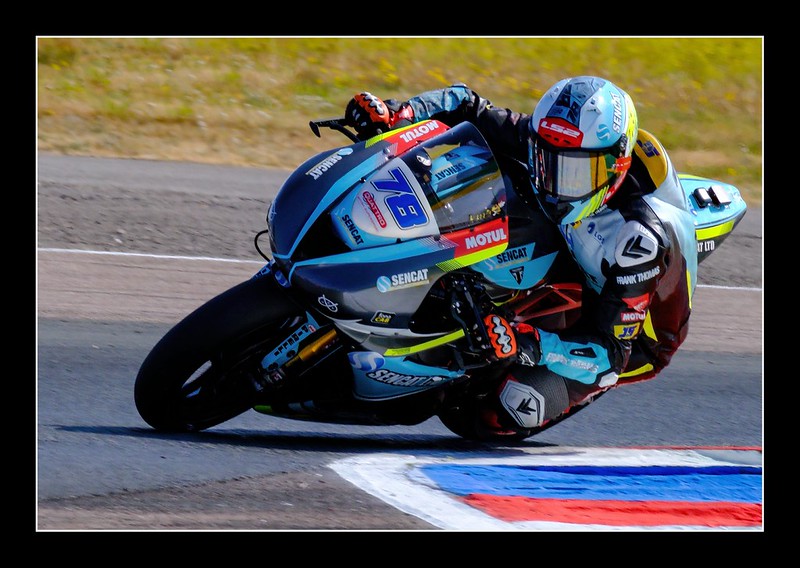 Motorcycle rider leaning into a corner at Thruxton Circuit